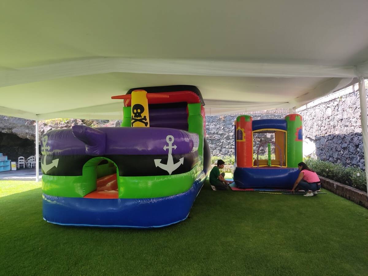 Jardín decorado para fiesta pirata con barco pirata inflable de 4 metros en CDMX