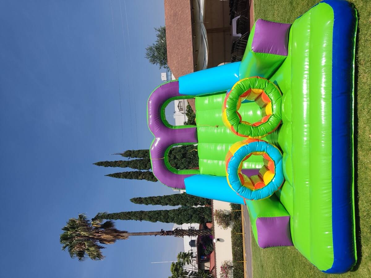 Alumnos de primaria compitiendo en el circuito inflable de obstáculos Circuito Extremo en el patio de una escuela de CDMX