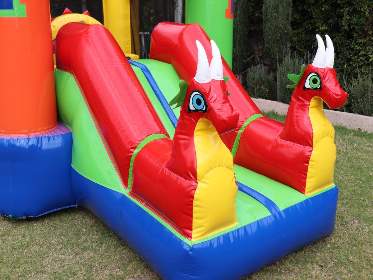 Niños y niñas jugando juntos en el inflable Dragones Rojos durante una fiesta en CDMX